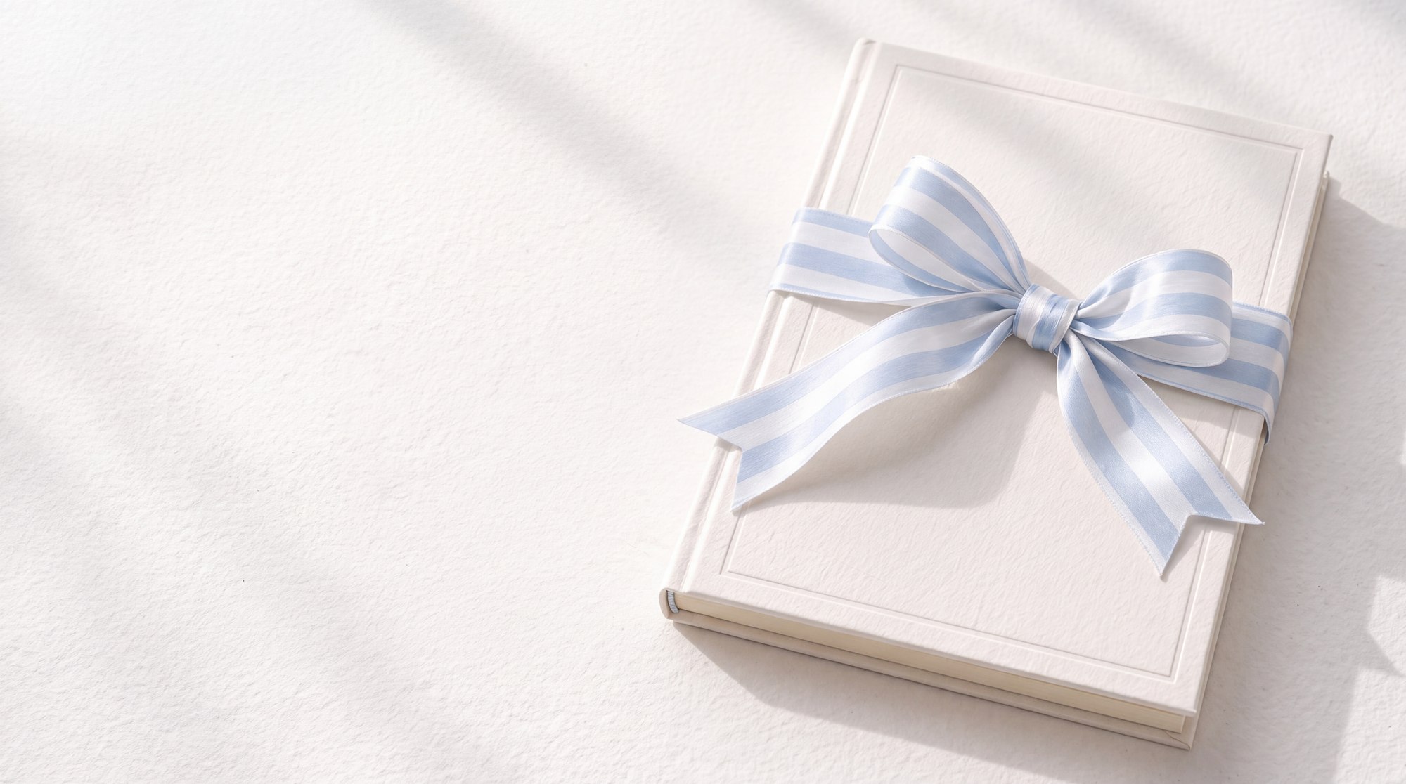 An ivory book tied with a striped powder-blue satin bow